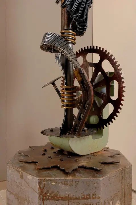 a metal sculpture with gears and a screw