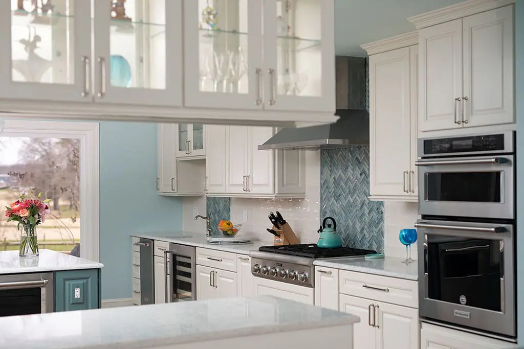 a kitchen with white cabinets and white counter tops