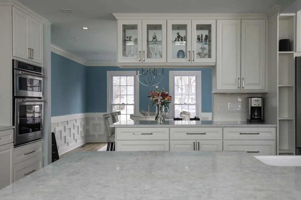 a kitchen with white cabinets and blue walls