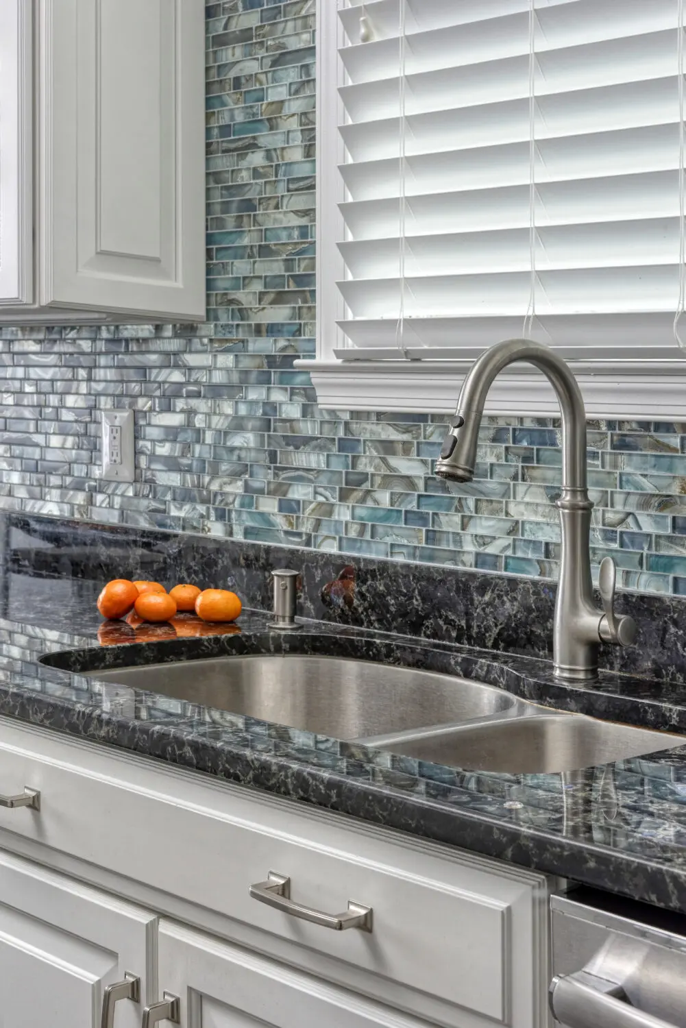 a kitchen sink with a faucet and oranges
