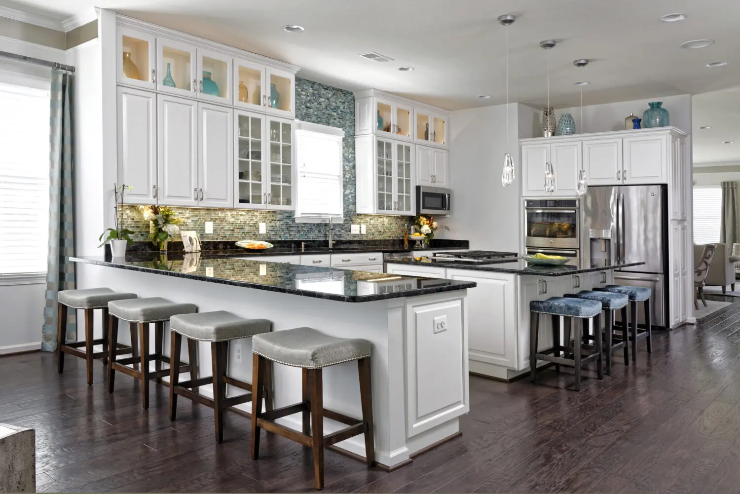 a kitchen with white cabinets and black counter tops