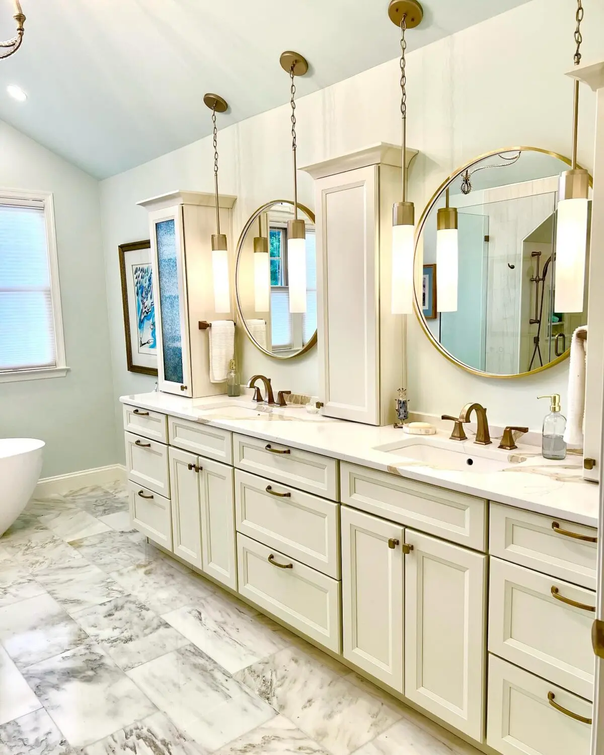 a bathroom with white cabinets and mirrors