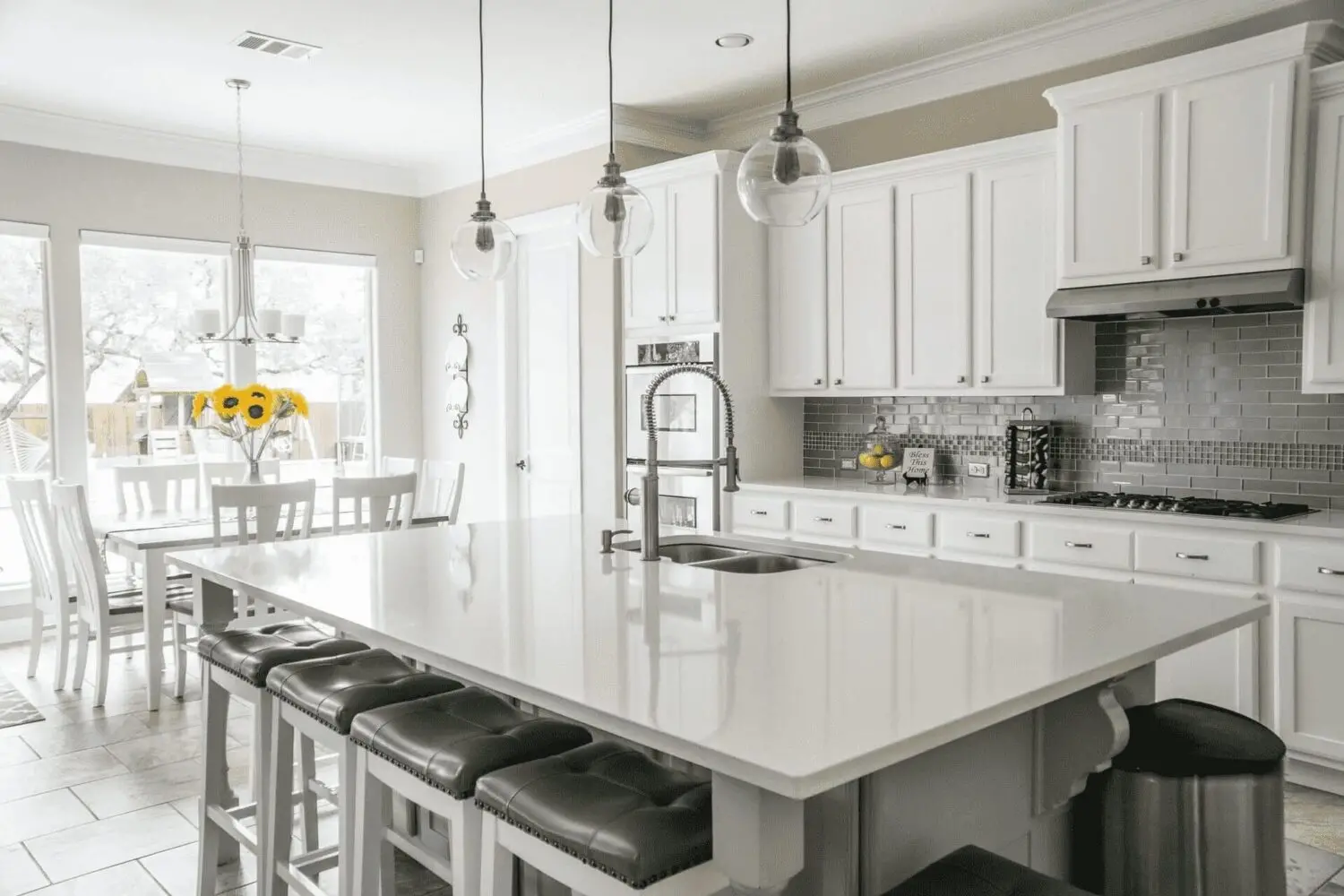 a kitchen with white cabinets and a large island