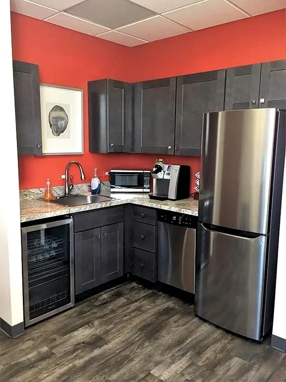 a kitchen with a stainless steel refrigerator and a wood floor