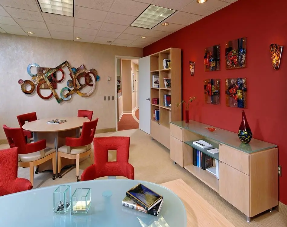 a room with red walls and a table and chairs