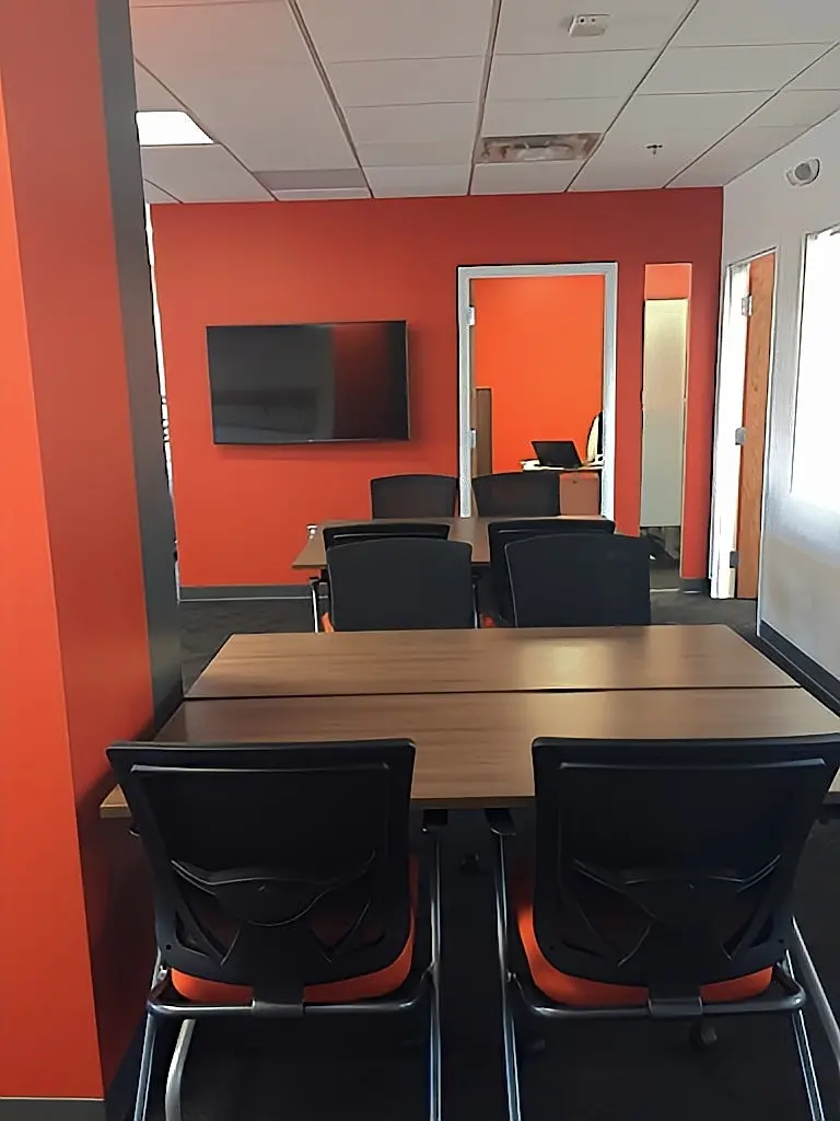 a room with orange walls and a table and chairs