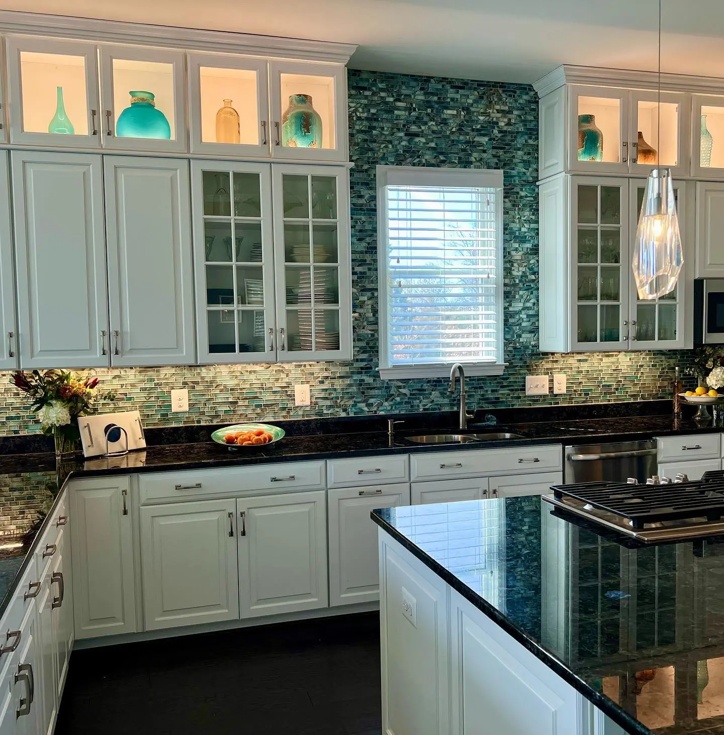a kitchen with white cabinets and black counter tops