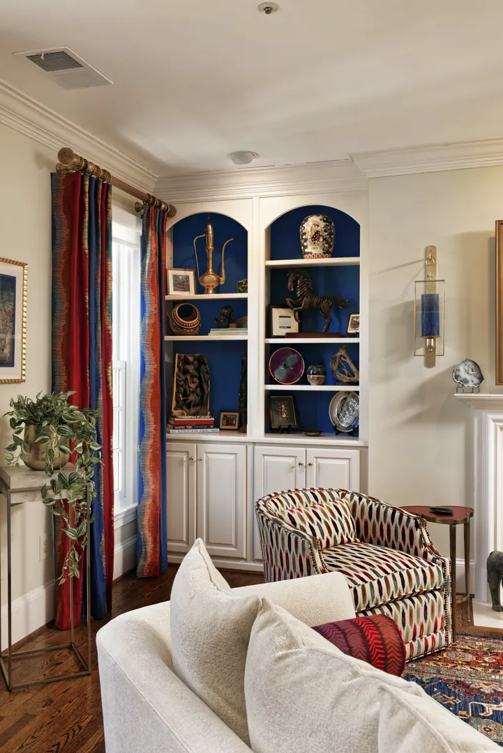 a living room with a chair and shelves